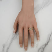 Alvio gold quinceañera tiara ring styled on hand display with marble backdrop.
