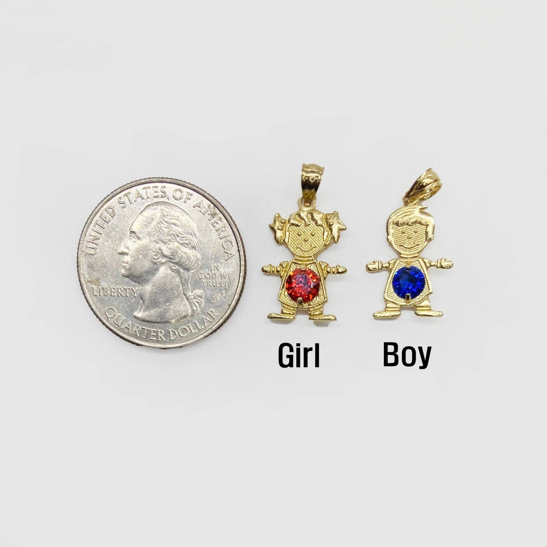 Size comparison of gold girl and boy birthstone pendants next to a US quarter.