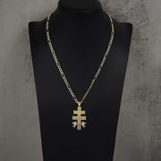 Tri-color gold Caravaca cross pendant necklace on figaro chain displayed on a mannequin bust.