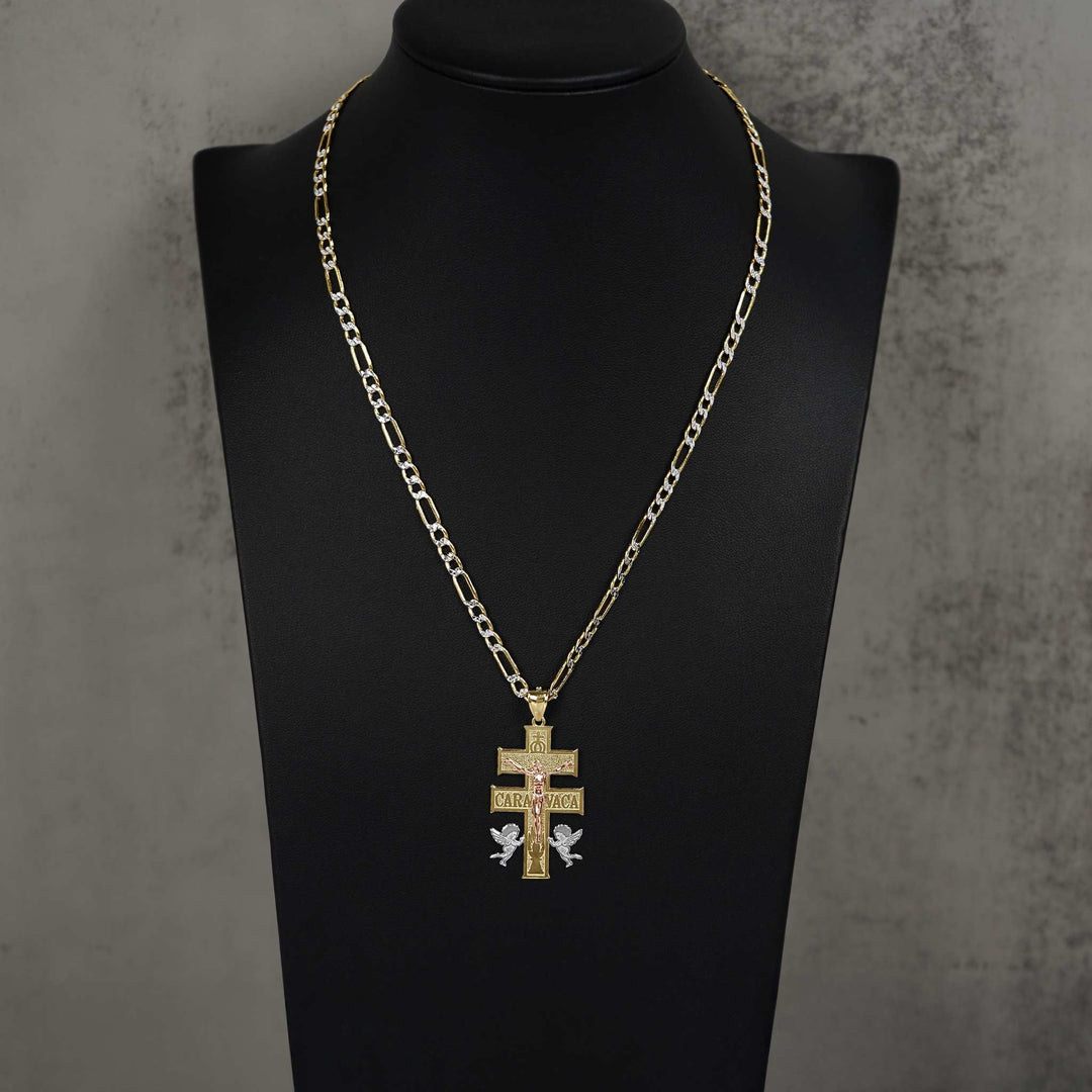 Gold Caravaca cross pendant on a Figaro chain, displayed on a black jewelry bust.