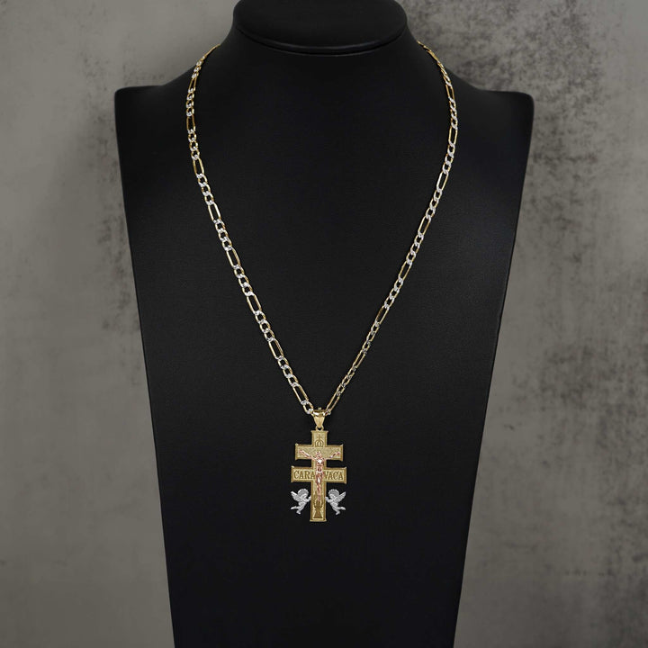 Gold Caravaca cross pendant on a Figaro chain, displayed on a black jewelry bust.