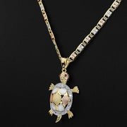 Front view of a tricolor 10k or 14k gold turtle pendant necklace with CZ accents.