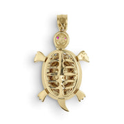 gold turtle pendant featuring an open-back textured shell and pink gemstone eyes
