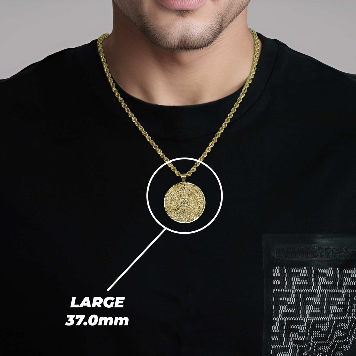 Man in black shirt showcasing a large gold pendant necklace with size text.