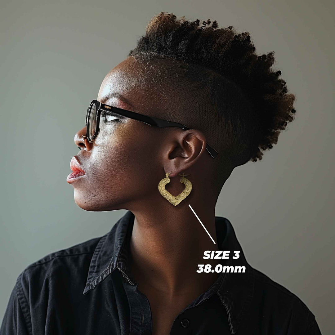 Descriptive: Side profile of a woman wearing 38mm 10k gold classic bamboo heart hoop earrings.