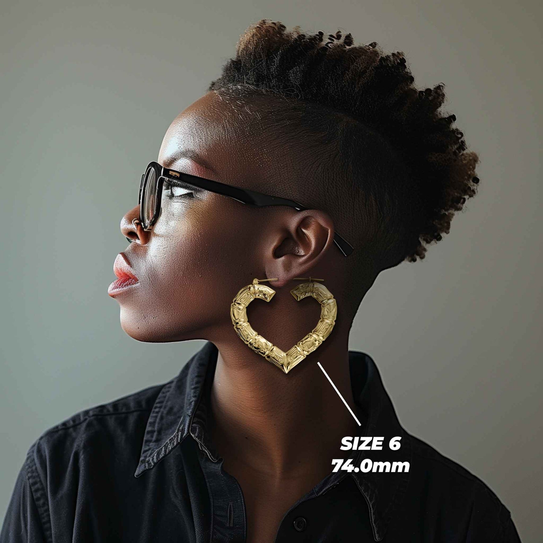 Side profile of a woman wearing 74mm 10k gold classic bamboo heart hoop earrings.