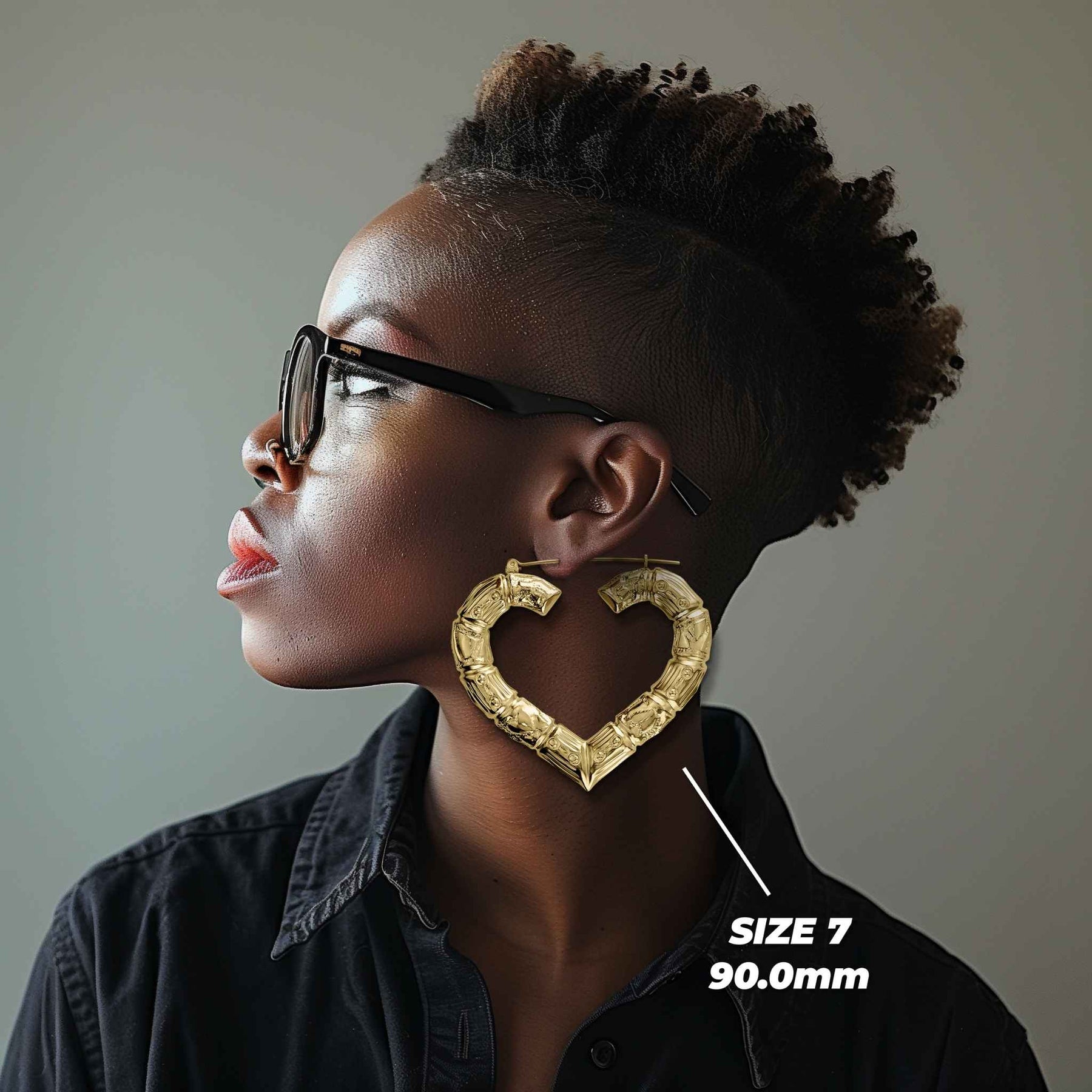 Side profile of a woman wearing 90mm 10k gold classic bamboo heart hoop earrings.