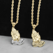 Two gold praying hands pendants, one two-tone and one yellow gold, on chains.
