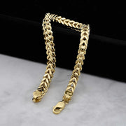 Detailed view of polished yellow gold Franco link chain bracelets with lobster clasps