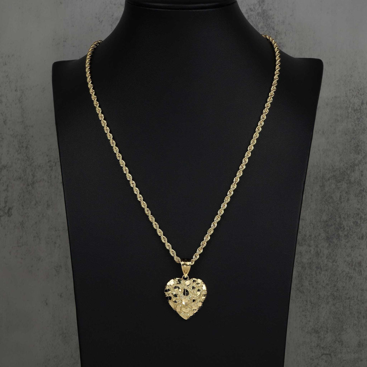 Gold heart nugget pendant necklace displayed on a black neck bust stand.