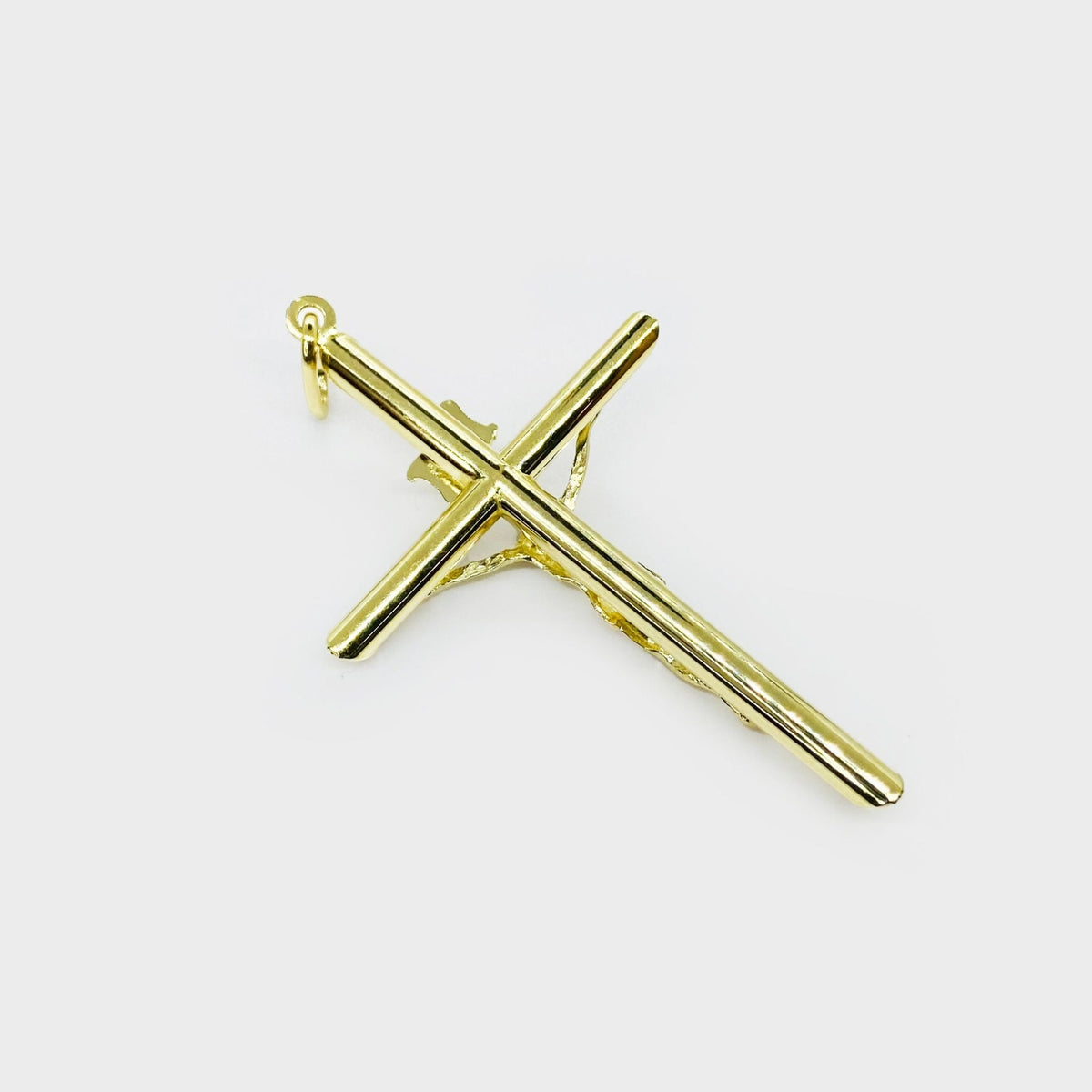 Rear view of gold Jesus crucifix cross charm showing recessed cross bars and bail loop.