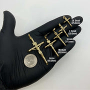 Five gold INRI crucifix pendants in hand showing sizes 25.0mm to 60.0mm.