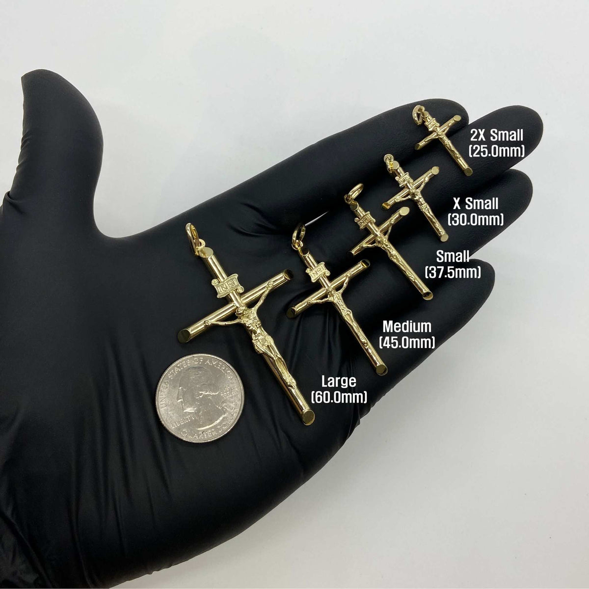 Five gold INRI crucifix pendants in hand showing sizes 25.0mm to 60.0mm.