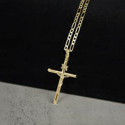 Yellow gold INRI crucifix cross pendant attached to a gold Figaro chain.