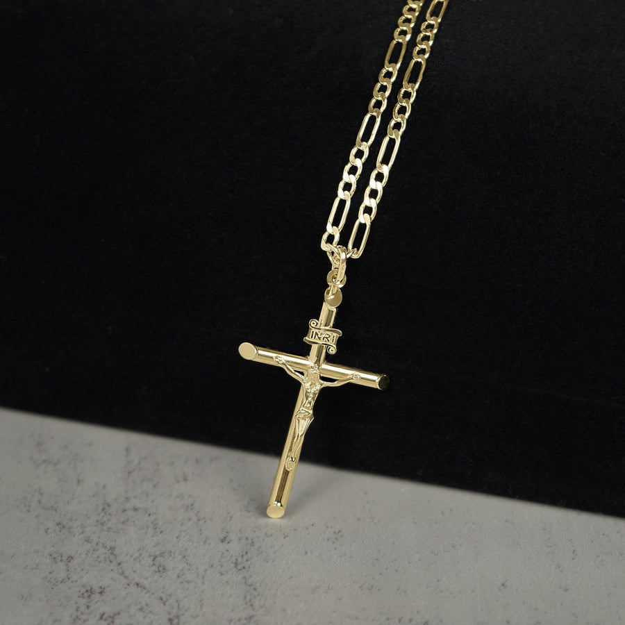 Yellow gold INRI crucifix cross pendant attached to a gold Figaro chain.