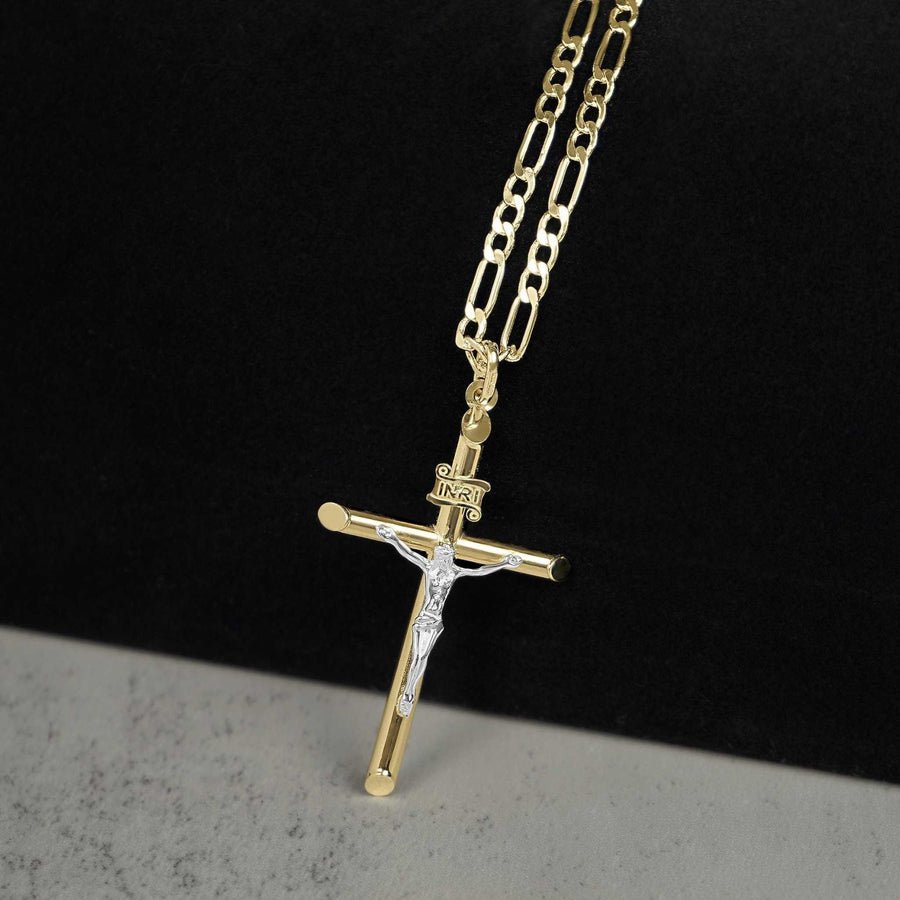 Two-tone gold INRI crucifix cross pendant hanging on a gold Figaro chain.
