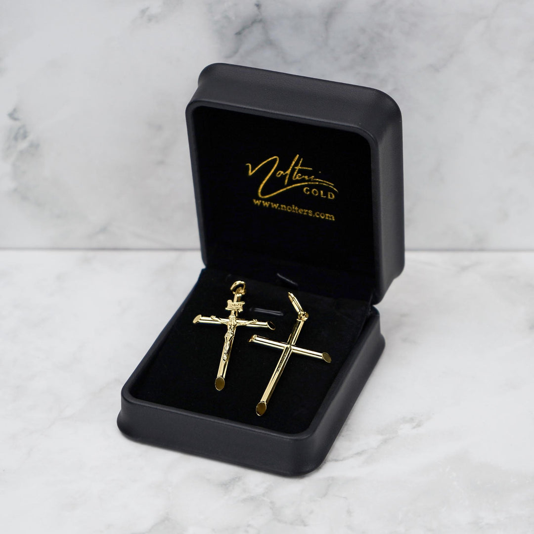 Yellow gold tube cross pendant in a black Nolters box on white marble.