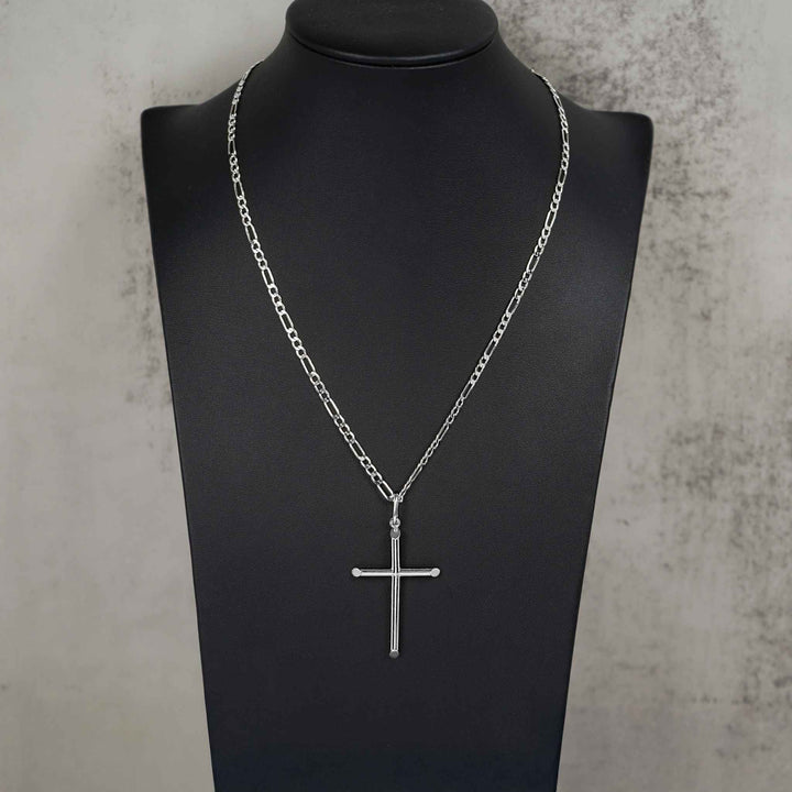 White gold tube cross necklace on a black mannequin against a textured gray background.