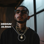 Man wearing the Medium Last Supper gold pendant with a 32.0mm size label overlay.