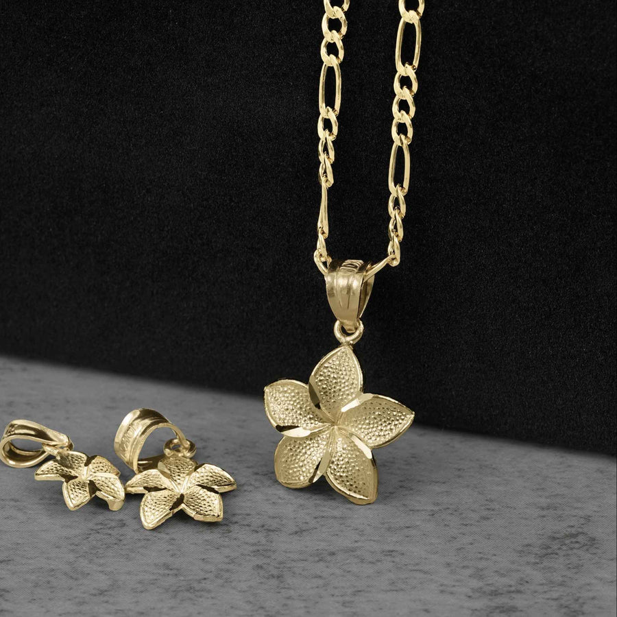 Close-up of a gold hibiscus flower pendant necklace and earrings set.