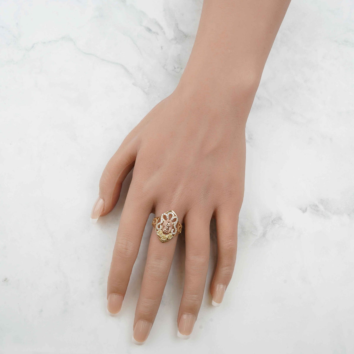 Top-down view of a hand wearing the 10k and 14k gold Virgin Mary ring.