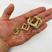 Small, medium, and large gold bamboo heart hoop earrings held on a hand with measurements.