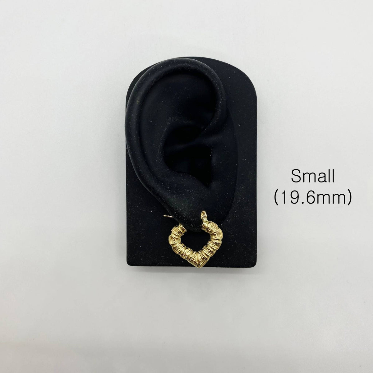 Small 19.6mm gold bamboo heart hoop earring displayed on a black ear model.