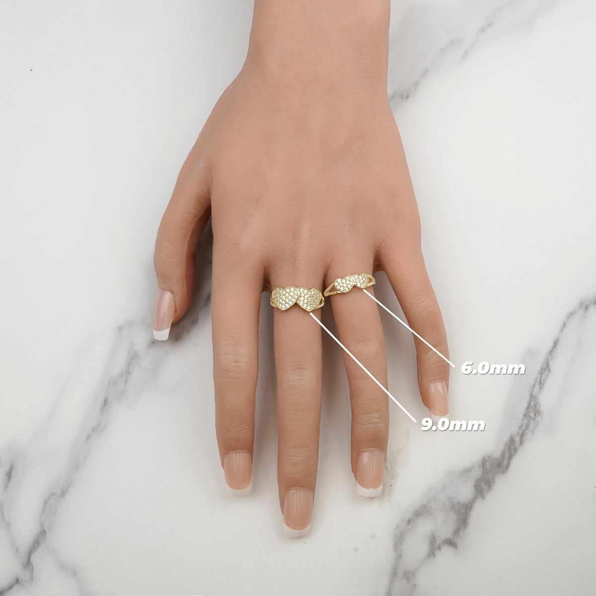 On-model size comparison displaying 6.0mm and 9.0mm gold dual heart CZ rings on hand