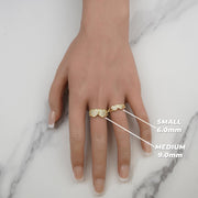 Hand wearing small and medium gold dual-heart rings labeled with heart dimensions.