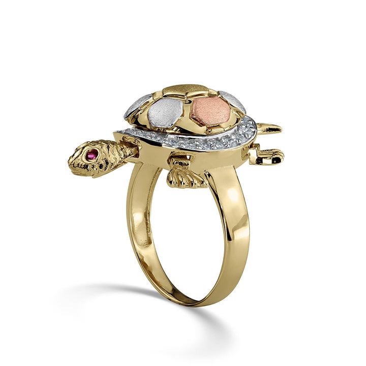 Side view of a tricolor gold Cari turtle ring with cubic zirconia on white background.
