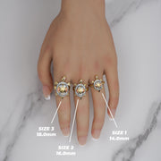 Three tricolor gold Cari turtle rings worn on a hand showing Size 1, 2, and 3.