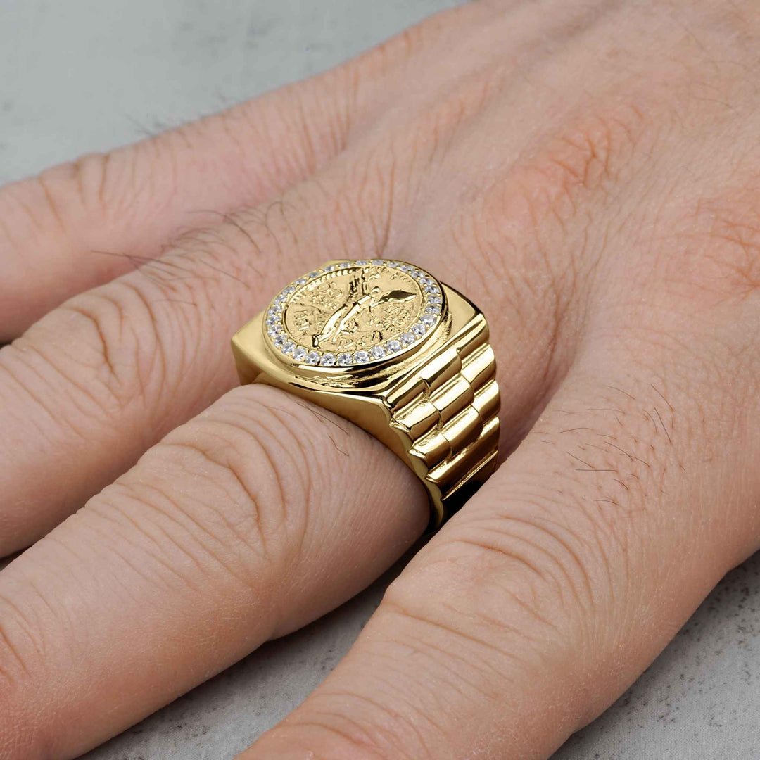 Close-up of men's gold Centenario pesos ring with cubic zirconia border on a hand.