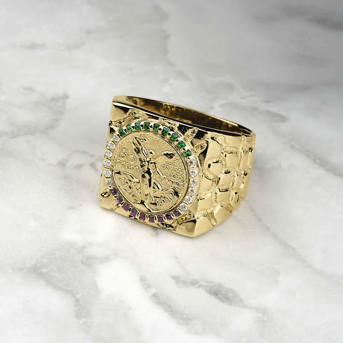 10k-14k gold square Centenario coin ring with colored stones on a marble surface.