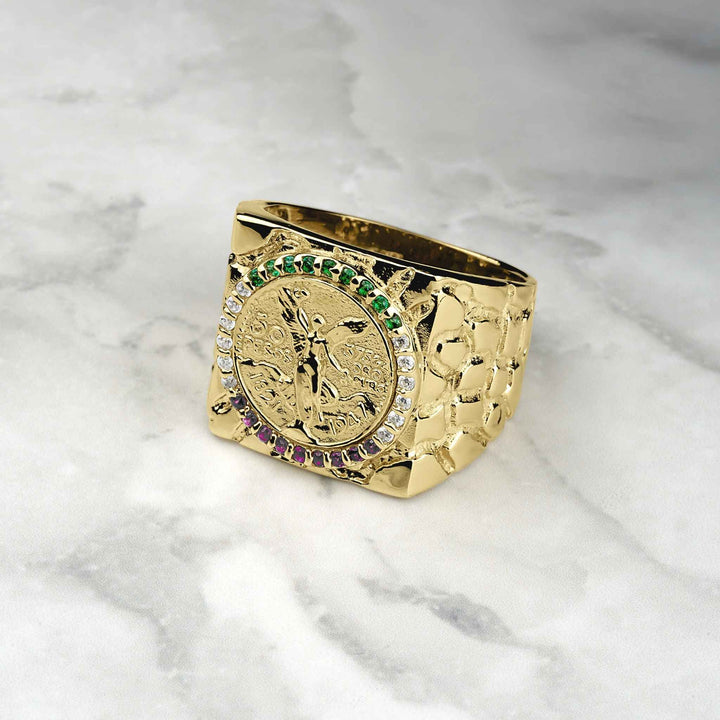 10k-14k gold square Centenario coin ring with colored stones on a marble surface.