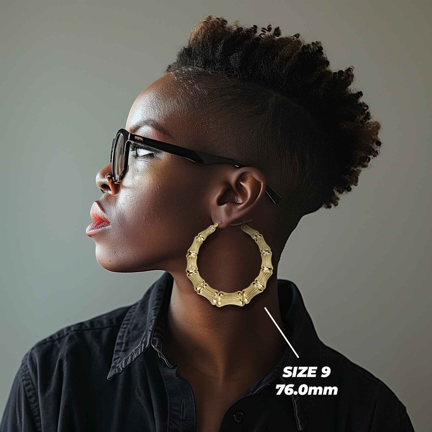 Side profile of a woman wearing 76mm 10k gold classic bamboo round hoop earrings.