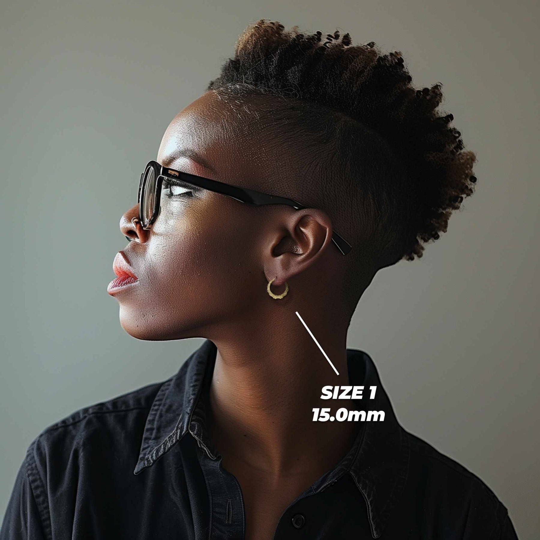 Side profile of a woman wearing 15mm 10k gold classic bamboo round hoop earrings.