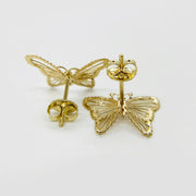 Rear view of gold butterfly stud earrings showing intricate textured cutouts and push-back posts.
