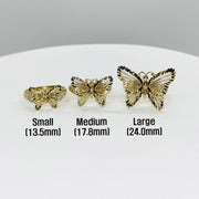 Three 10k - 14k gold butterfly shaped rings in different sizes on a white surface.