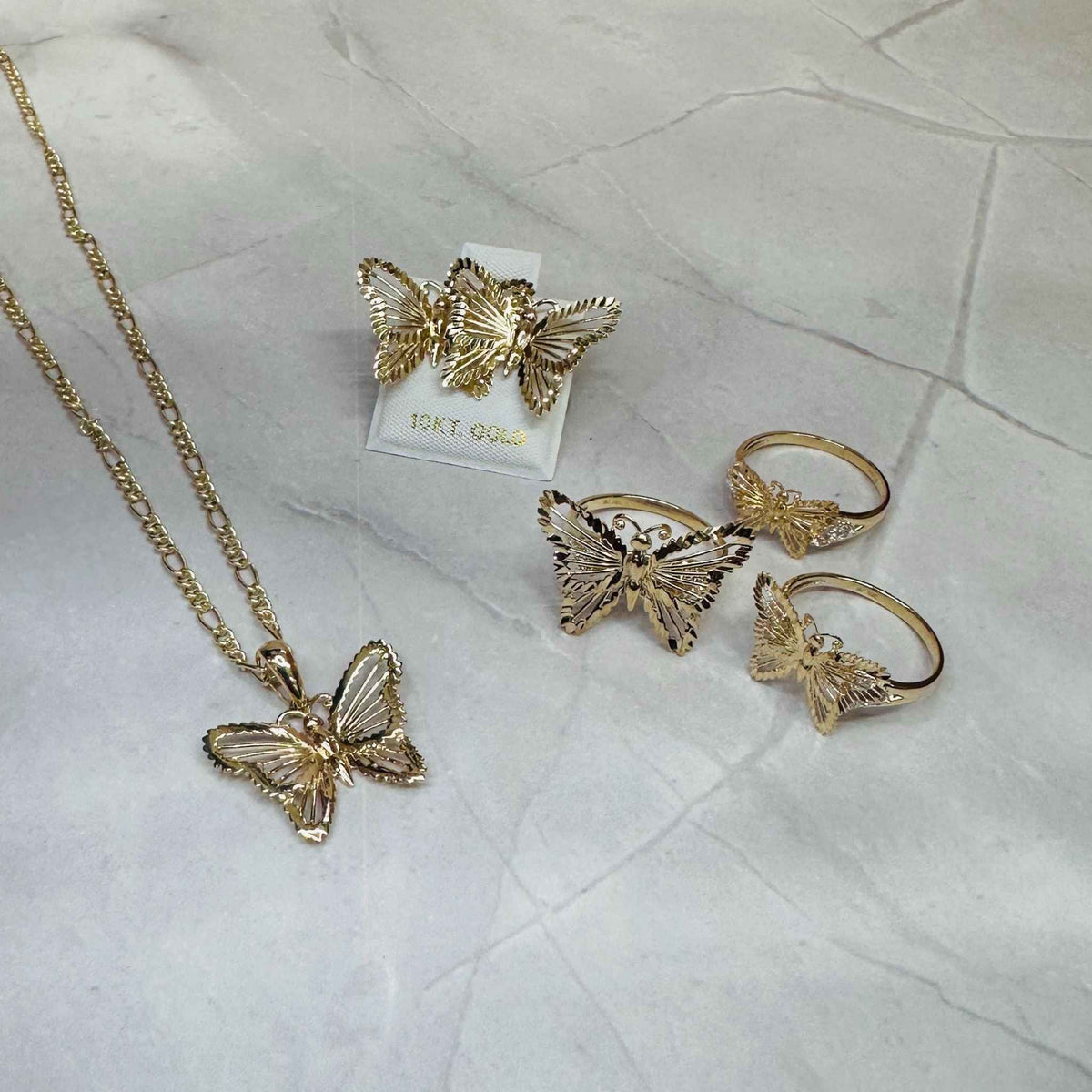 10k - 14k Gold butterfly-themed jewelry set including necklace, earrings, and rings.
