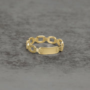 Close-up of a yellow gold ID ring featuring a polished center nameplate.