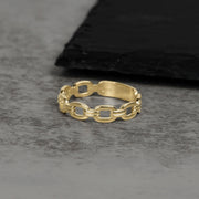 Solid 10k or 14k gold classic Rolo chain link ring on a gray surface.