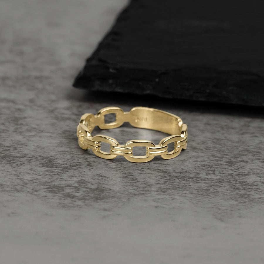 Solid 10k or 14k gold classic Rolo chain link ring on a gray surface.