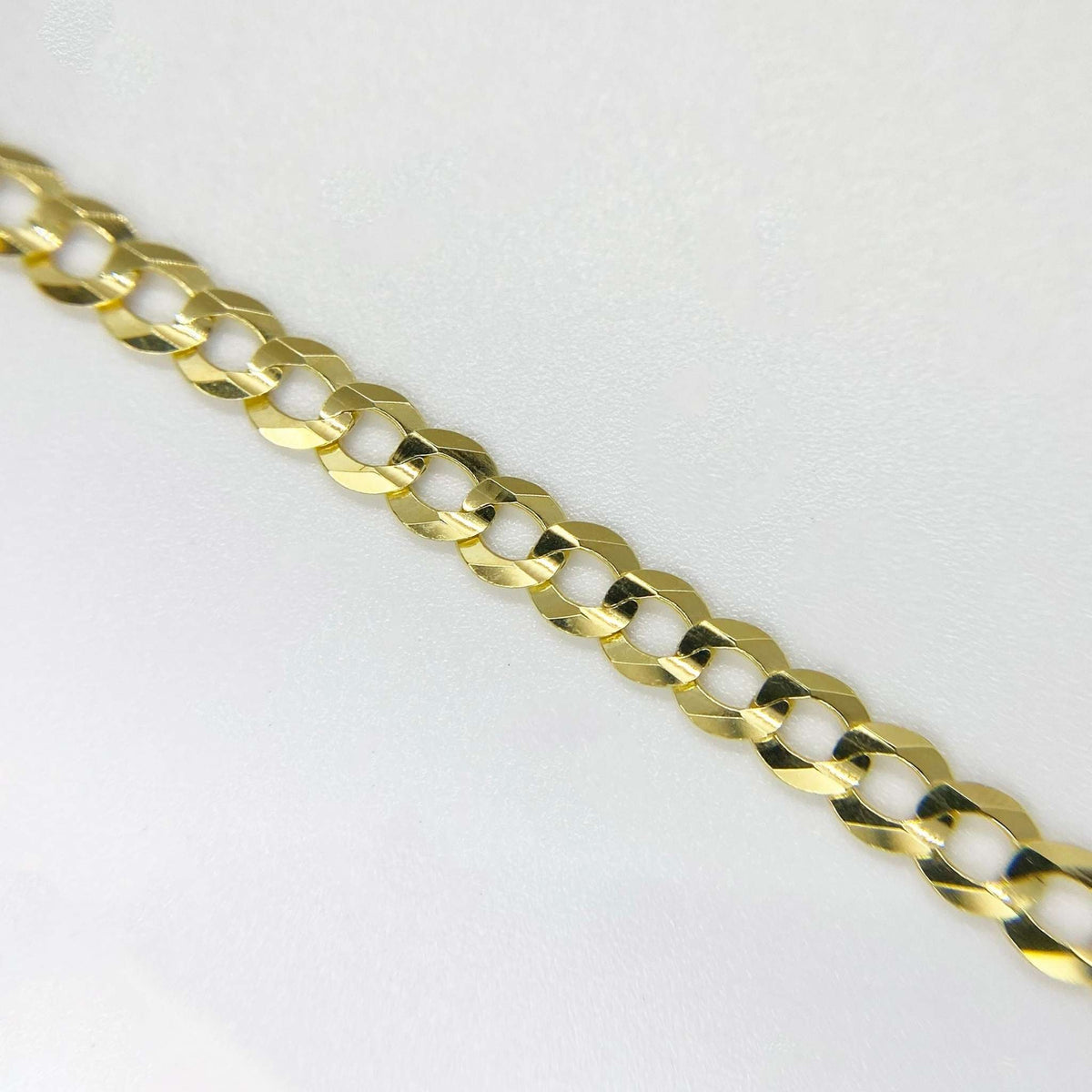 Detailed close-up view showing the flat, interlocking links of a solid gold Cuban curb chain.