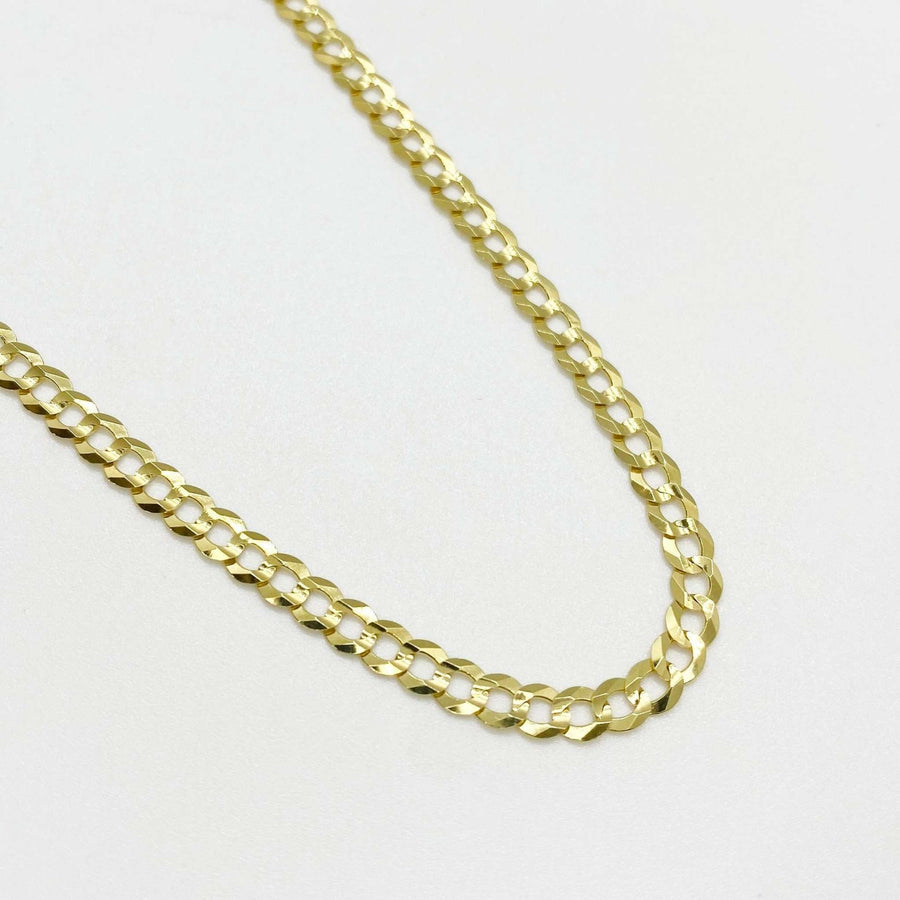 Polished yellow gold classic Cuban curb chain necklace on white background.