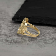 A side angle capturing the gleaming finish and layered profile of a gold nugget ring.