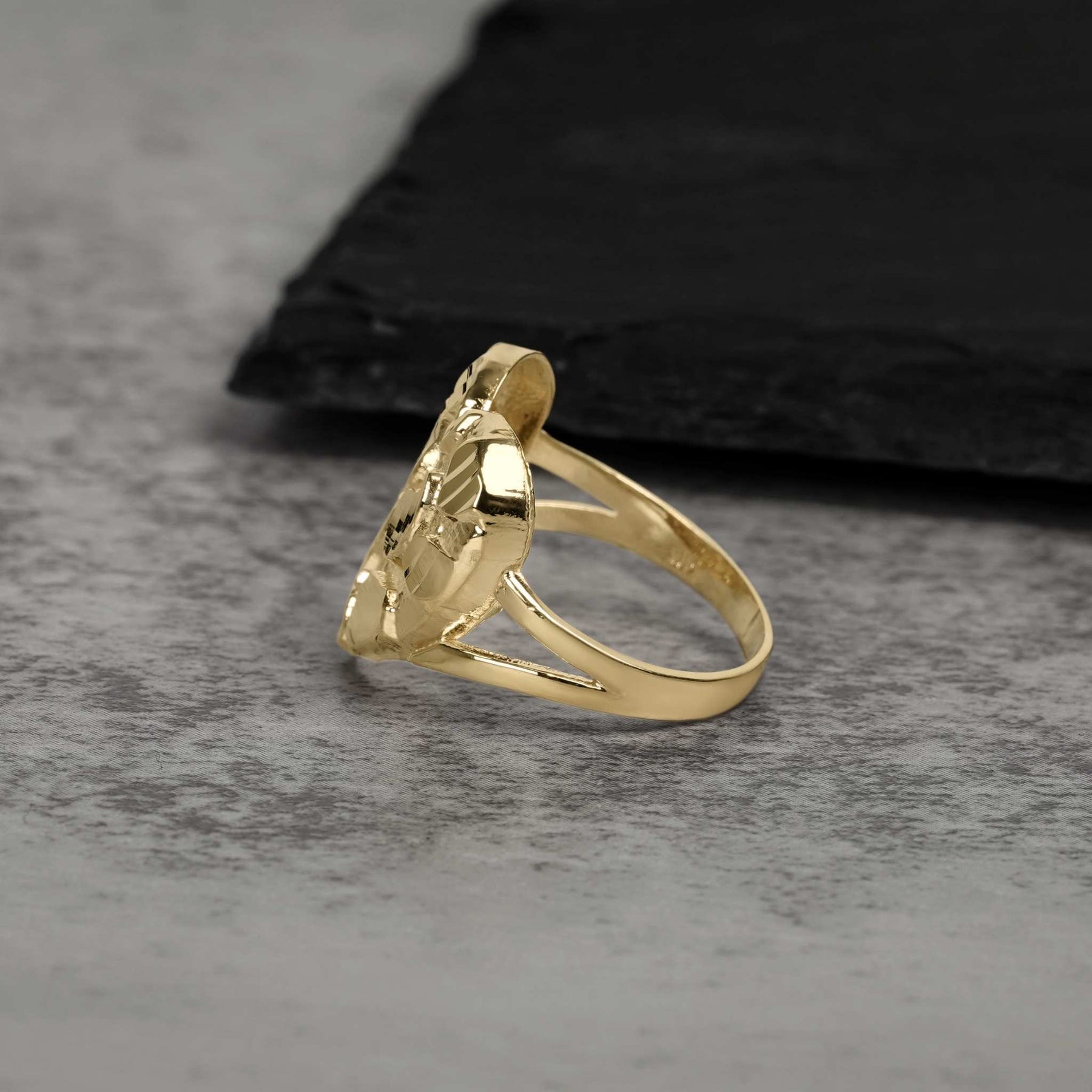 A side angle capturing the gleaming finish and layered profile of a gold nugget ring.