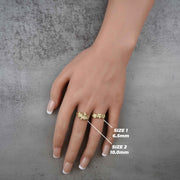 Hand wearing two 10k - 14k gold rings with floral design size labels.
