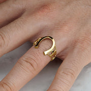 High-polish gold horseshoe signet ring shown worn on a man's finger.
