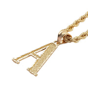 Ornate 14k gold initial 'A' pendant with diamond-cut filigree on a gold rope chain.