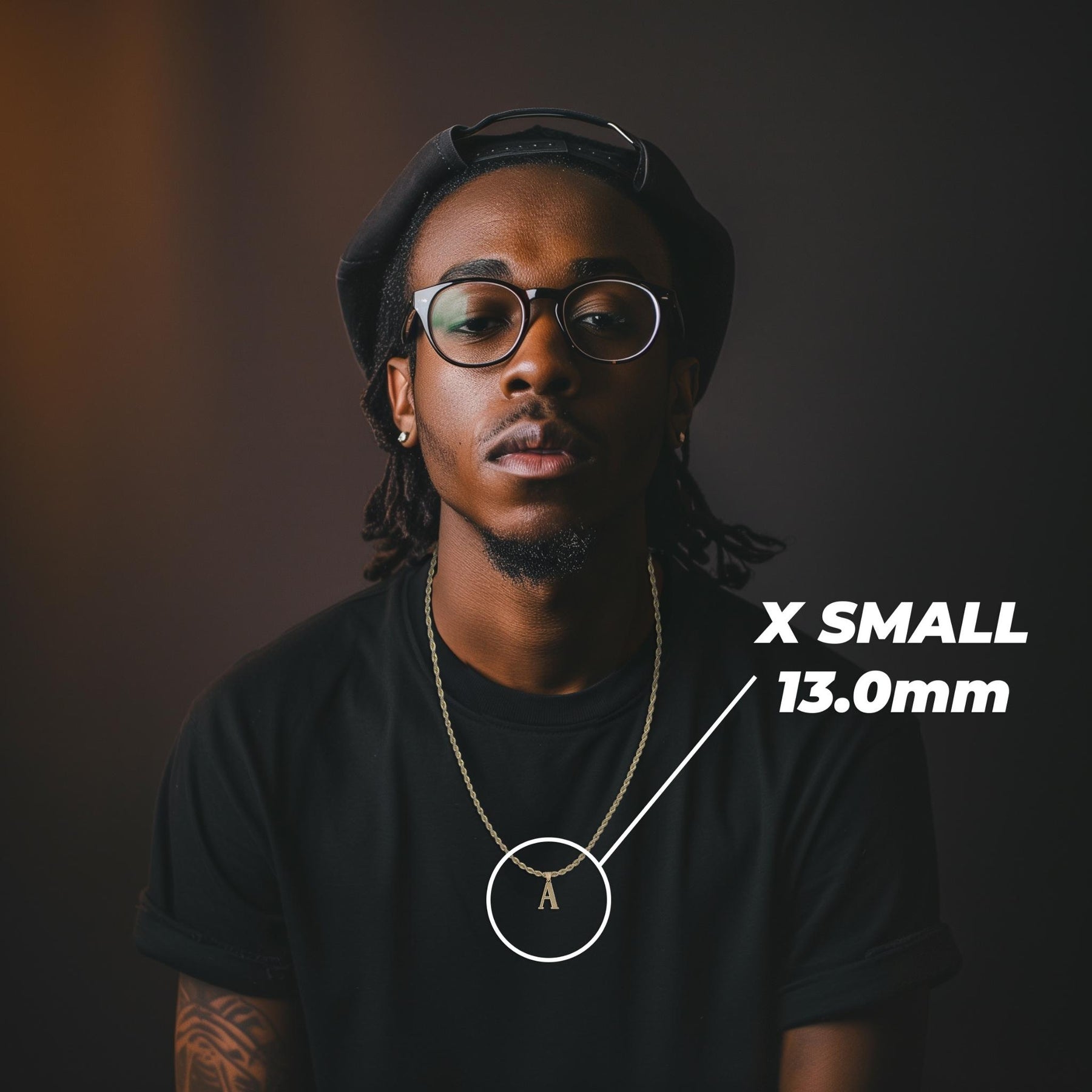 Model wearing an extra-small 13mm gold initial 'A' pendant labeled X SMALL 13.0mm.